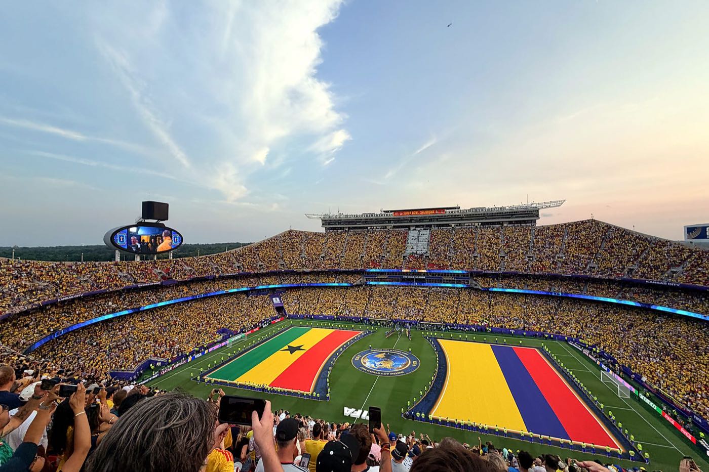 Giant team flags spread across the pitch around the FIFA World Cup 2026 logo at Arrowhead Stadium before a match
